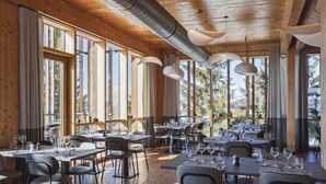 A spacious dining area with multiple tables and chairs, large windows, and wooden ceiling beams. - Aiguille Grive Chalets Hôtel (Bourg-Saint-Maurice)