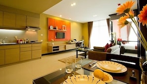 Una cucina moderna con zona pranzo, divano e televisore.