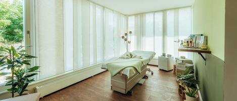 A room with a bed, a radiator, a plant, and a shelf with items.