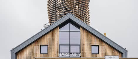 A modern building with a unique spiral tower and a wooden facade.