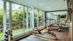 A gym with rowing machines, a treadmill, and a mirror reflecting the room. - Torfhaus HARZRESORT (Clausthal-Zellerfeld)