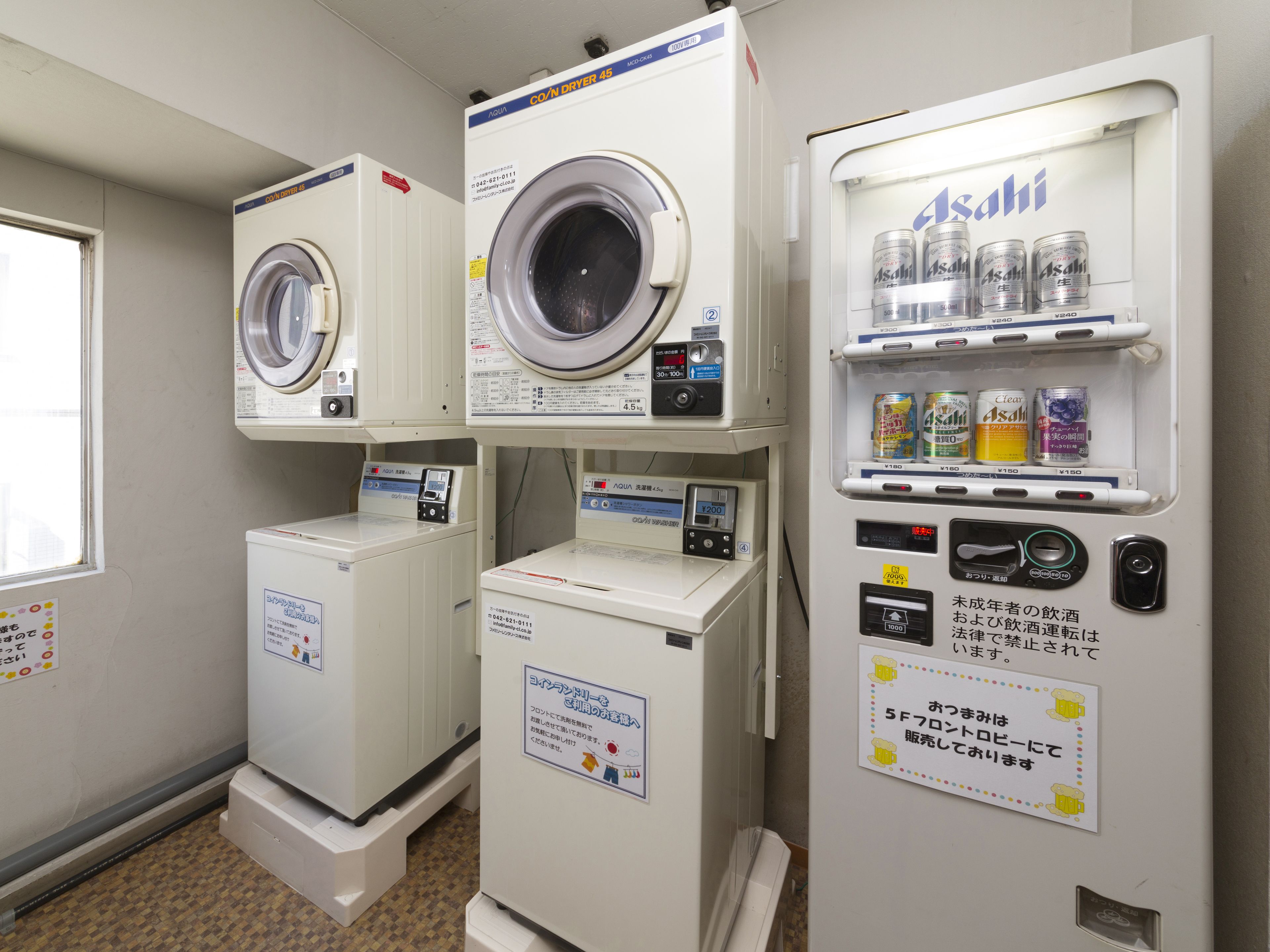 A laundry area with multiple washing machines and a vending machine.