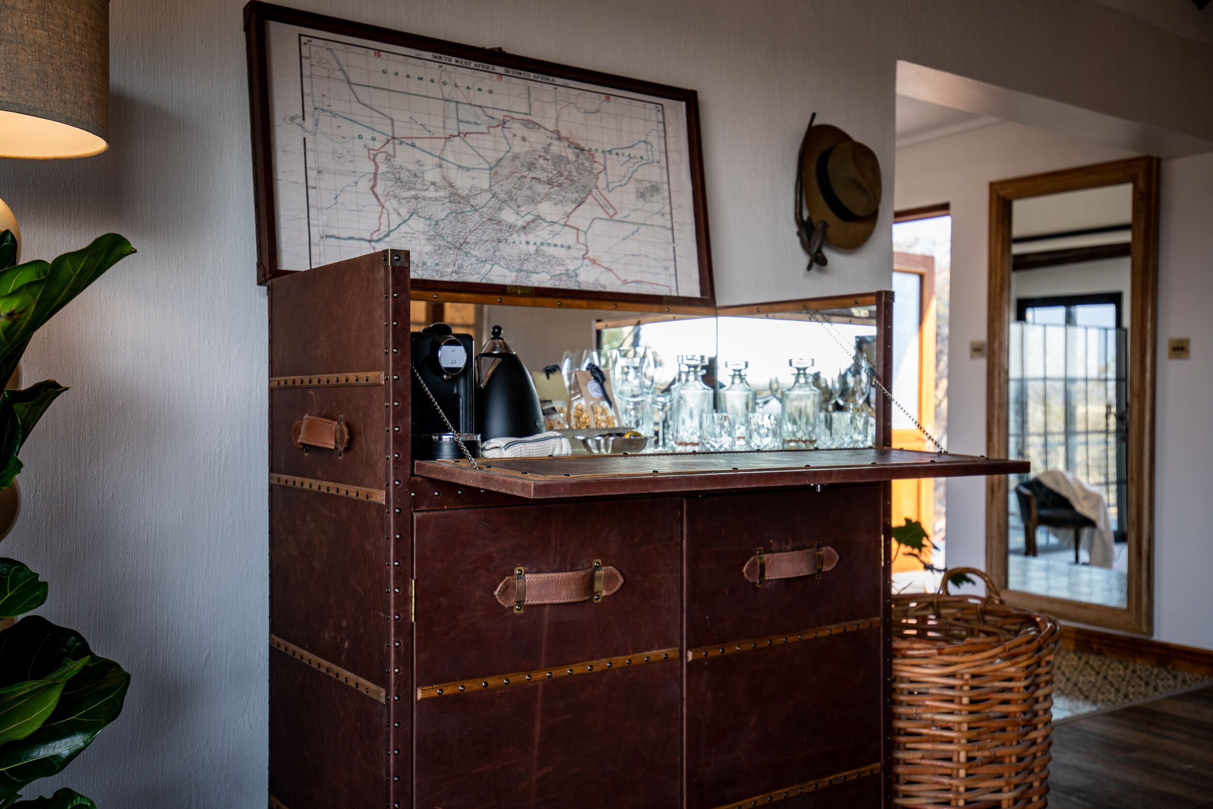 Un aparador de madera antiguo con cristalería y un mapa en la pared de arriba.