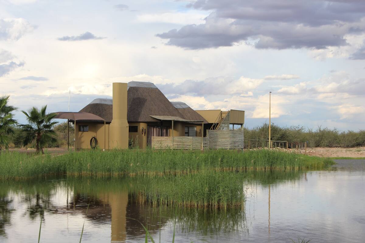 Ein Gebäude mit außergewöhnlichem architektonischen Design, gelegen an einem Gewässer mit umgebender Vegetation.