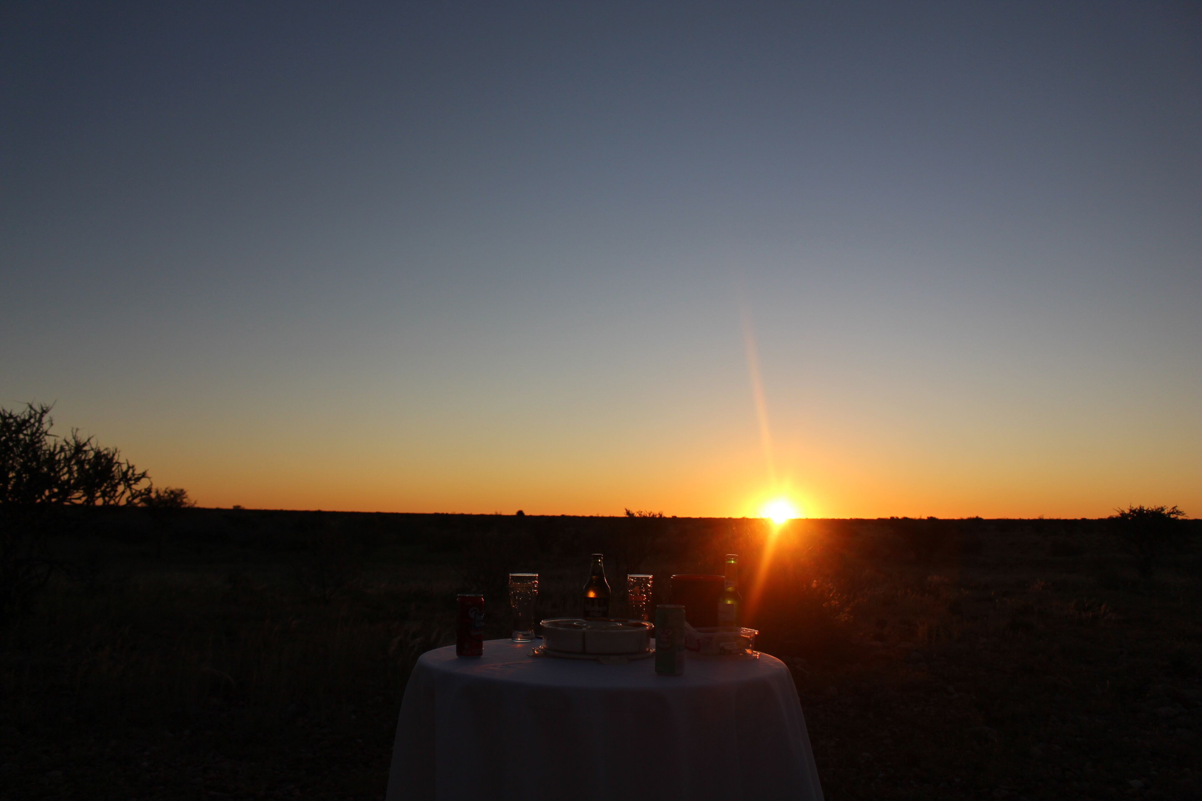 A table set outdoors with a sunset in the background.