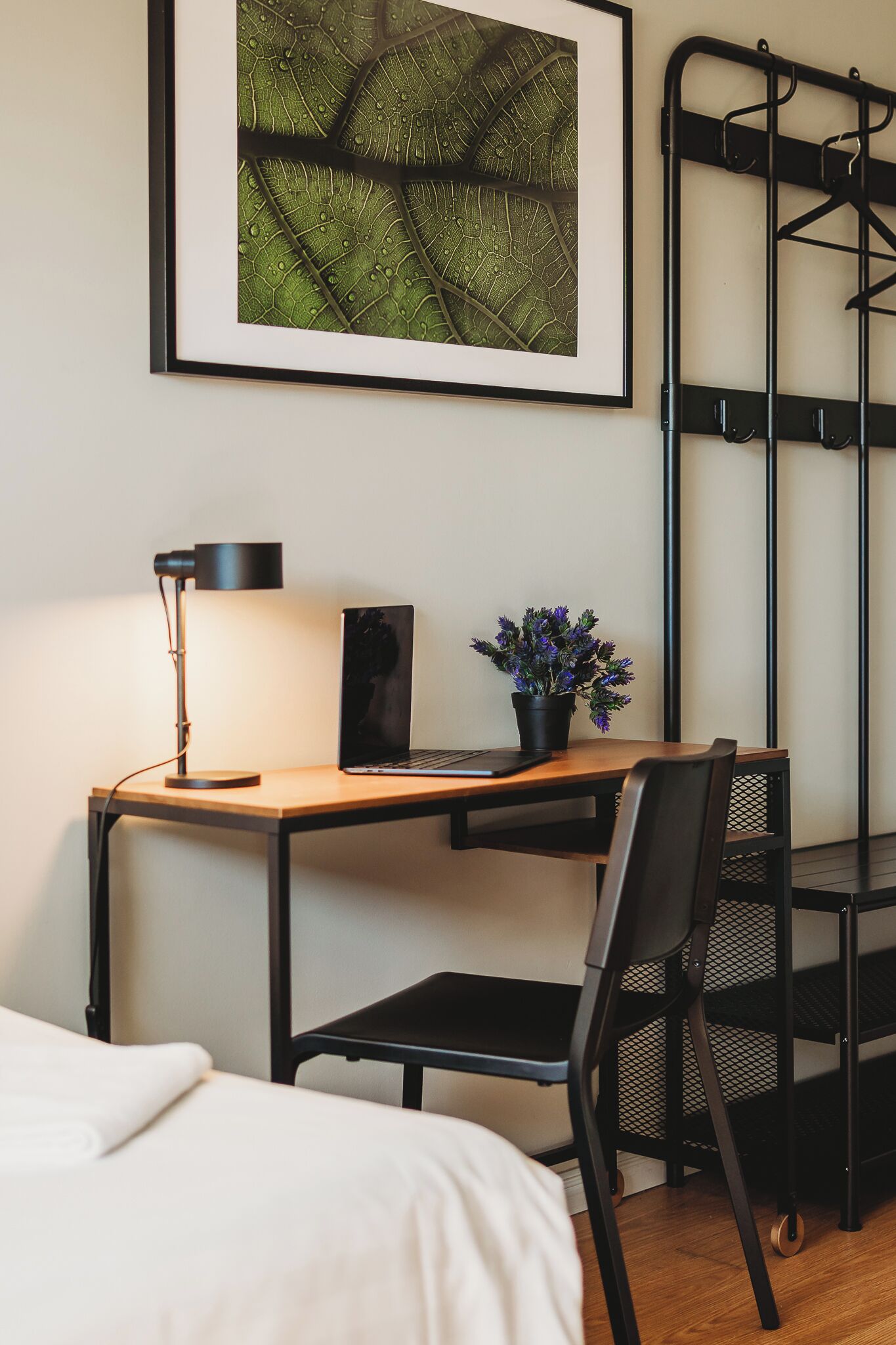 A neatly arranged workspace with a desk, chair, laptop, lamp, and a potted plant.