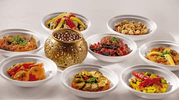 Une table avec différents plats servis dans des bols, un vase décoratif doré et un bol à motifs.