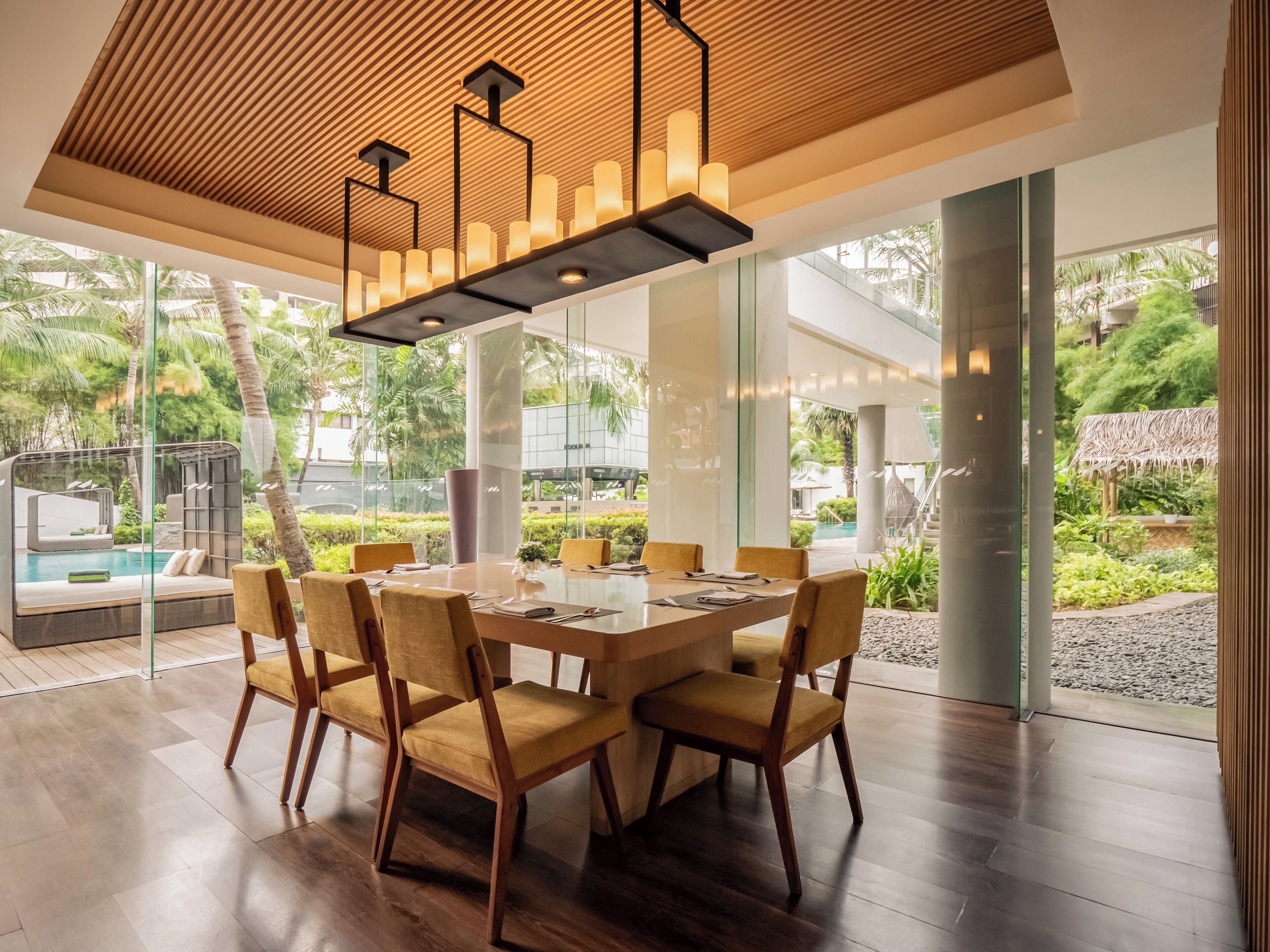 Un comedor moderno con una mesa grande, sillas y una lámpara colgante.