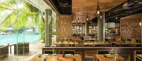 A restaurant with a pool view, wooden furniture, and modern lighting.