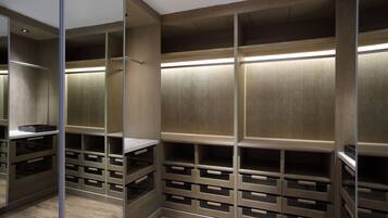 Un vestidor con puertas espejadas, estanterías de madera e iluminación integrada.