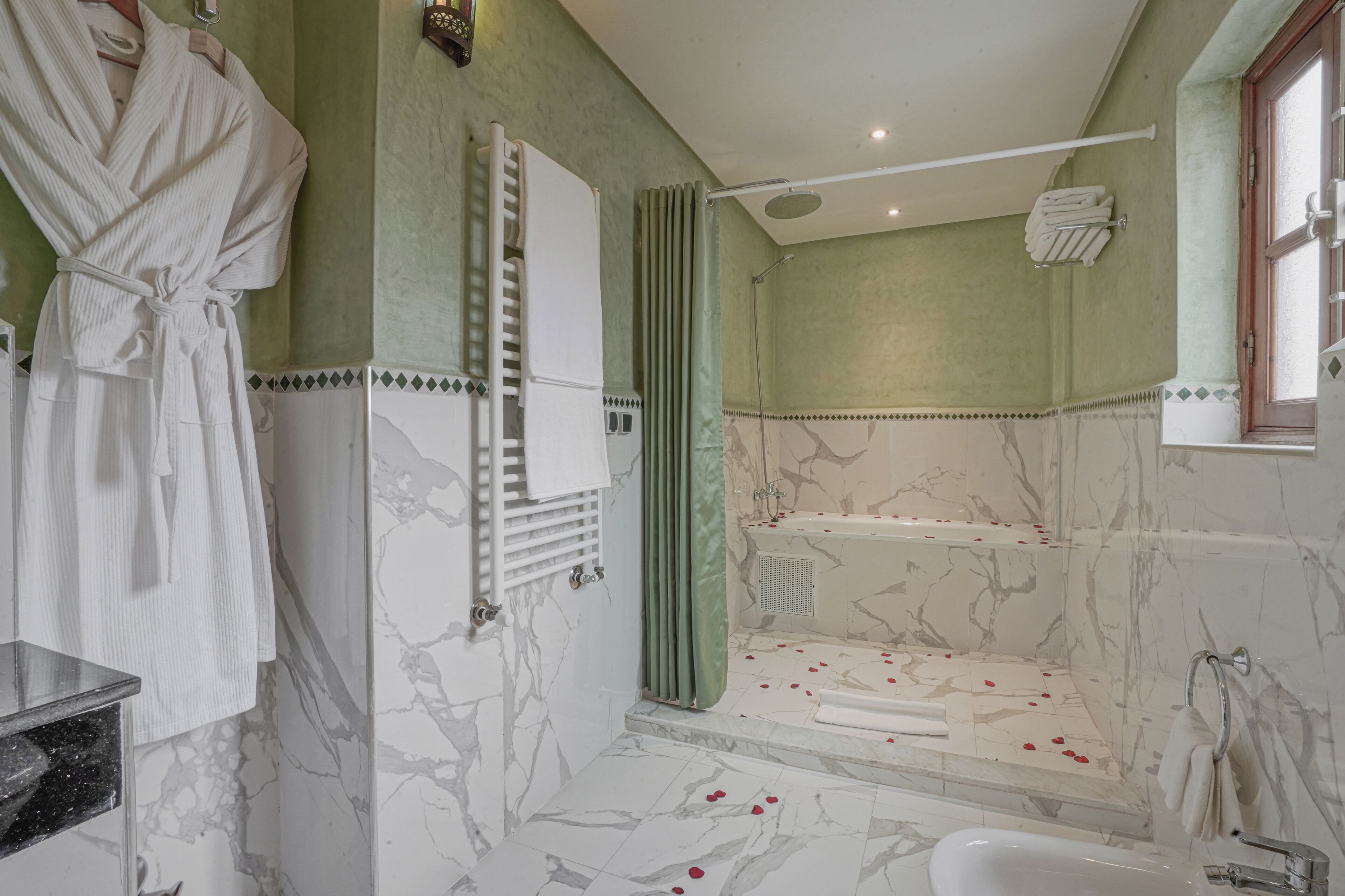 Ein Badezimmer mit Badewanne, Dusche und Waschtisch mit Spiegel.