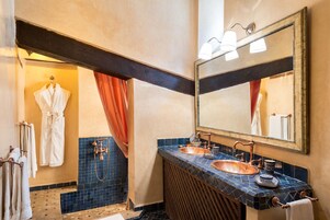 Casa de banho com duas pias, um espelho grande e zona de duche.