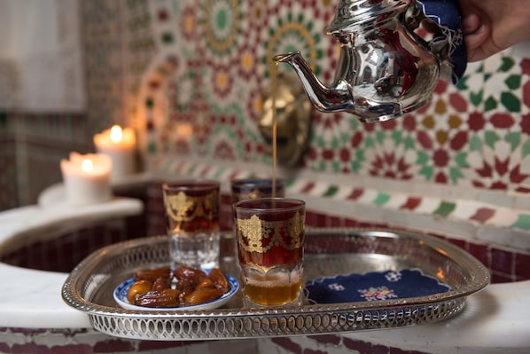A tray with glasses and a teapot, with a candle in the background. - Algilà Fes Riad Medina Charme Hotel Spa (Fes)