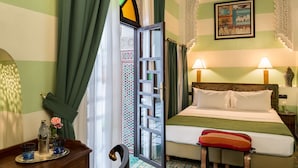 A hotel room with a bed, two bedside lamps, a tray with a bottle and glasses, and a window with curtains. - Algilà Fes Riad Medina Charme Hotel Spa (Fes)