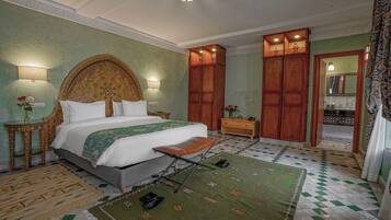 Une chambre avec un grand lit, une armoire en bois et un tapis à motifs verts.
