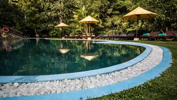 Una piscina al aire libre, sillones reclinables de piscina