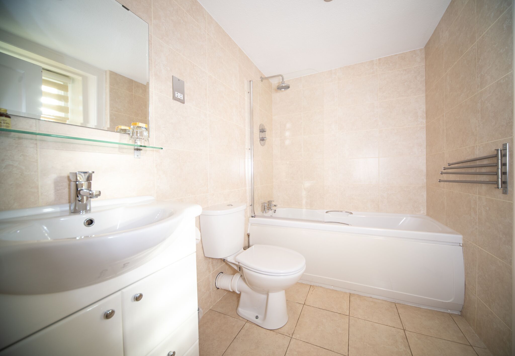 A modern bathroom with a sink, toilet, and bathtub.