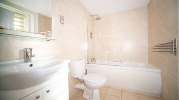 A modern bathroom with a sink, toilet, and bathtub.