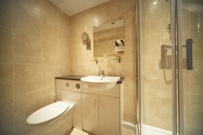 Un baño moderno con inodoro, lavamanos y zona de ducha.