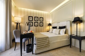 A hotel room with a bed, desk, chair, and lamps.