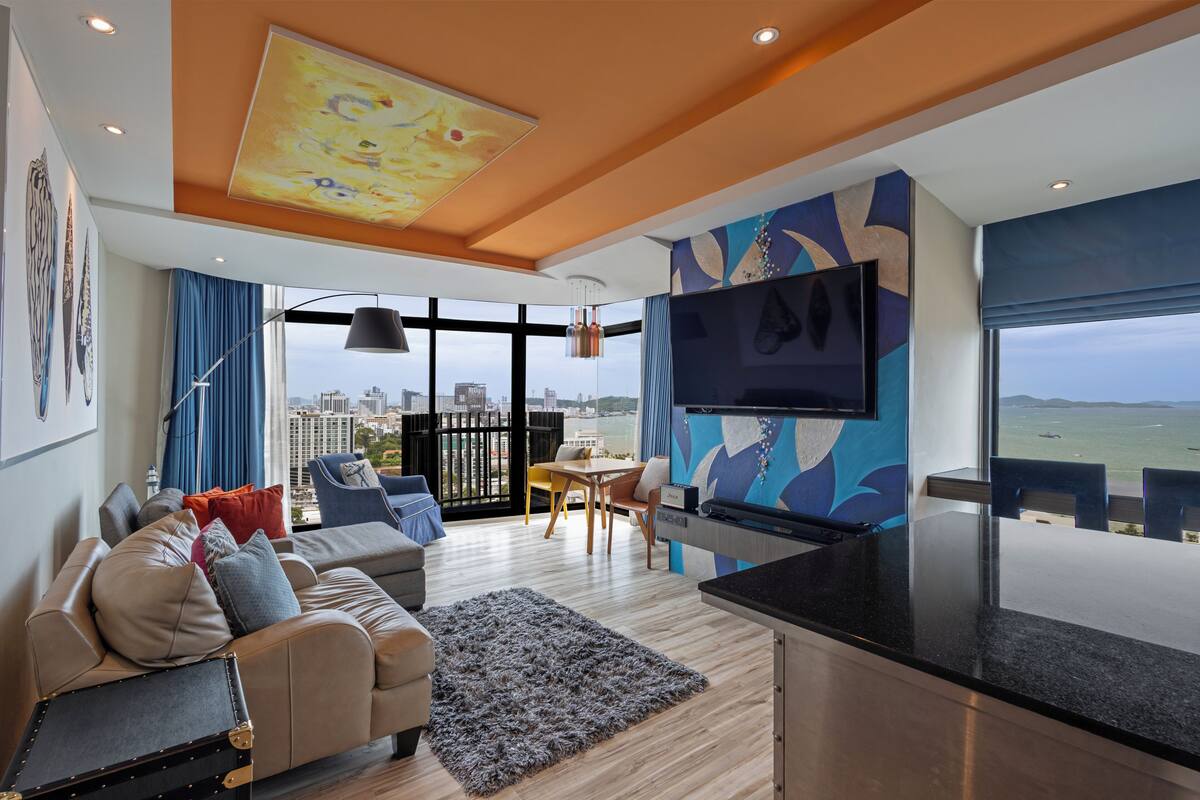 Una sala moderna con un sofá, una mesa de comedor y una zona de cocina.