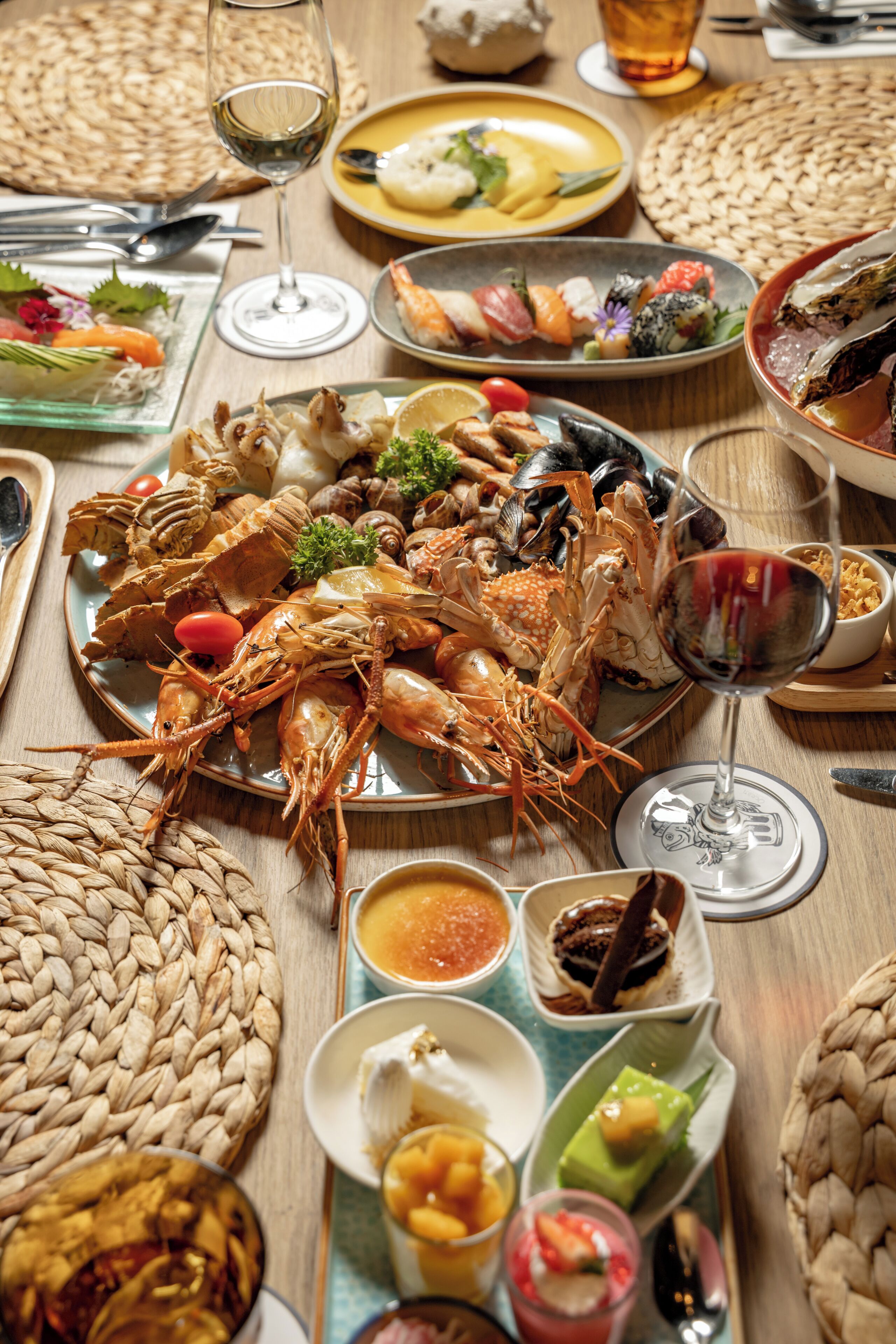 A table set with various seafood dishes, wine glasses, and condiments.