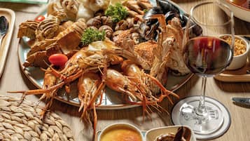 A table set with various seafood dishes, wine glasses, and condiments.