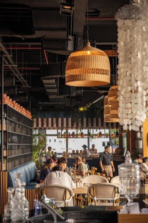 A restaurant interior with a bar area, seating, and hanging light fixtures. - Siam@Siam Design Hotel Pattaya (Pattaya)
