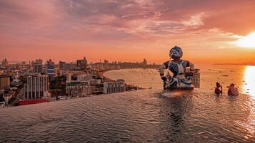A statue in a body of water with a cityscape in the background.