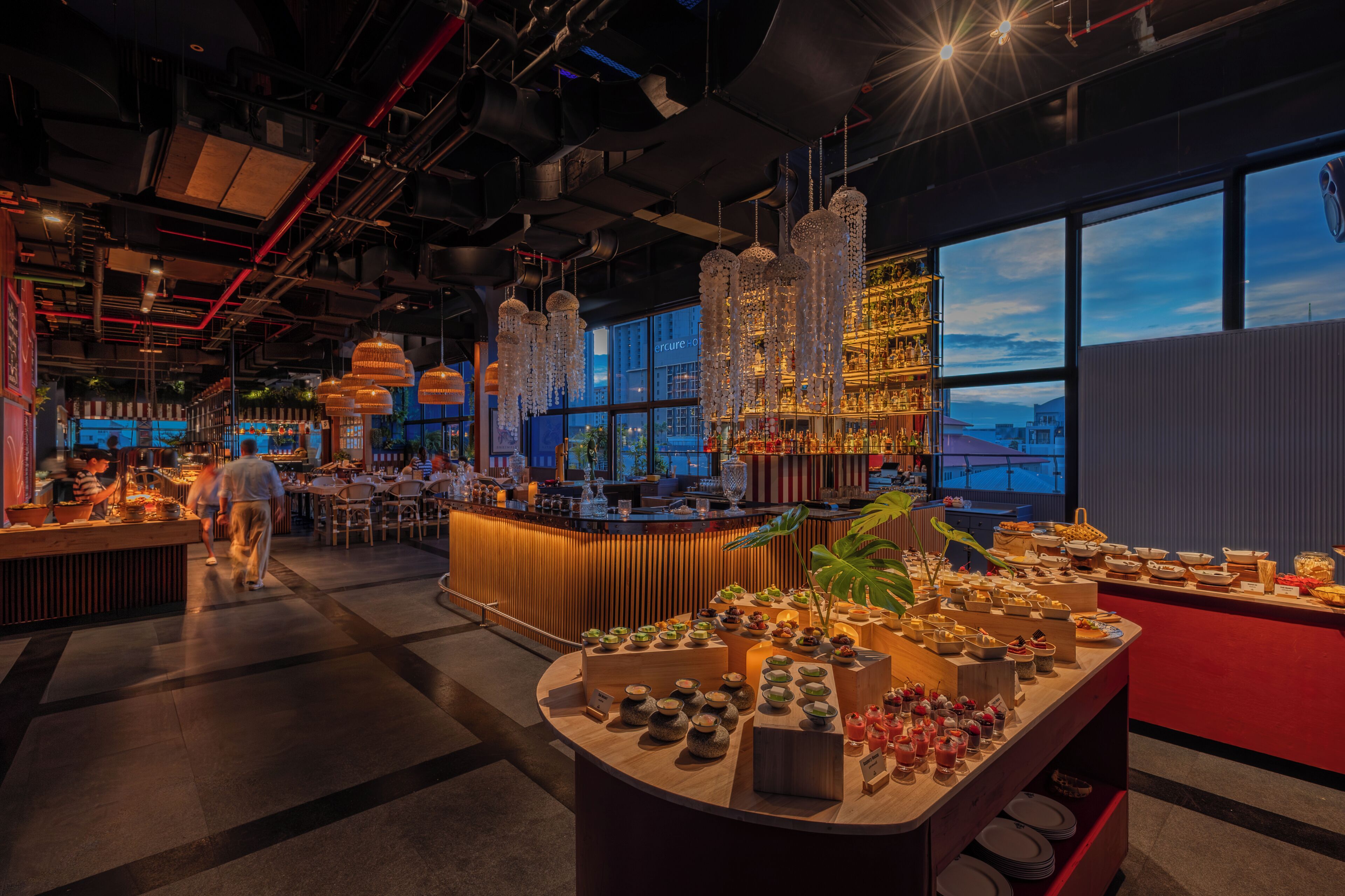 A bar area with a variety of bottles and a buffet with multiple dishes.