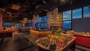 A bar area with a variety of bottles and a buffet with multiple dishes.