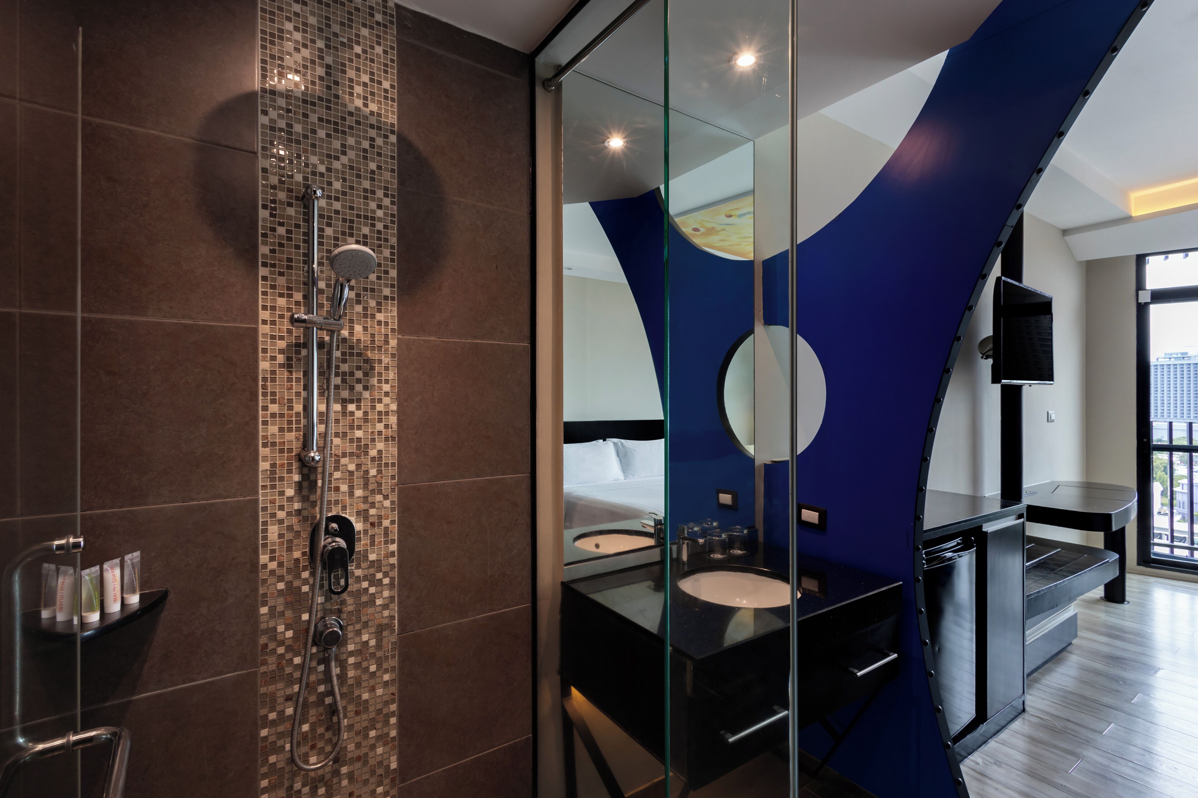 A modern bathroom with a glass shower enclosure, a double sink vanity, and a large mirror.