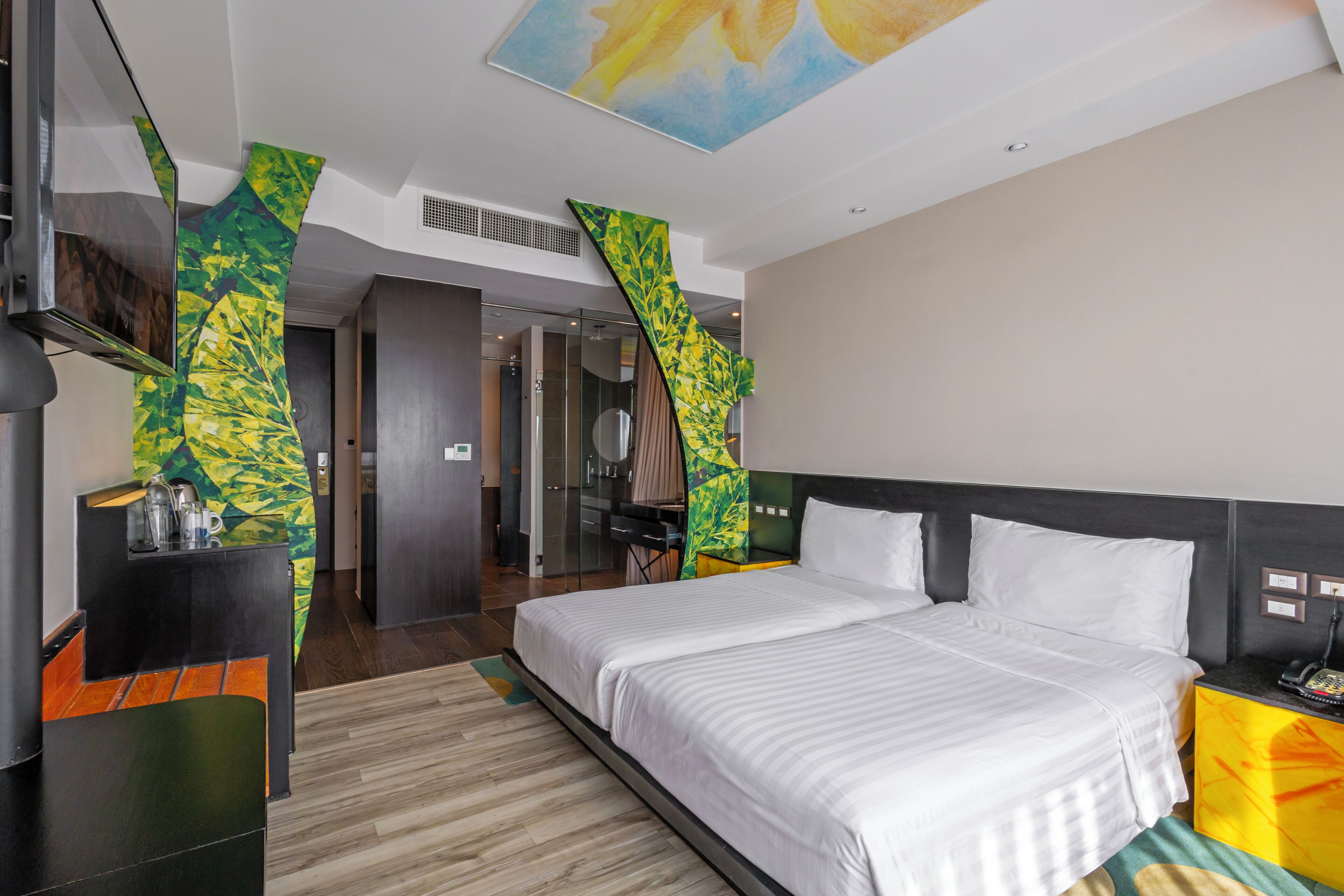 A hotel room with a bed, a desk, and a TV.
