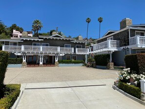 A large, two-story house with a spacious front yard, a balcony, and a stone chimney. - Inn on Summer Hill (Santa Barbara)