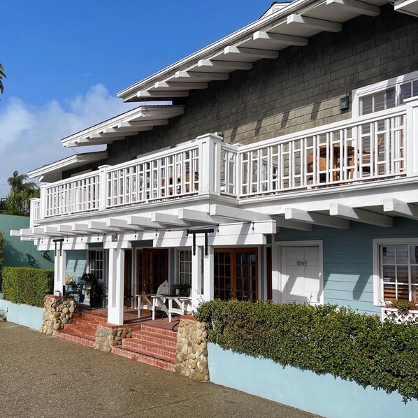 A two-story house with a balcony, stone steps, and a hedge. - Inn on Summer Hill (Santa Barbara)