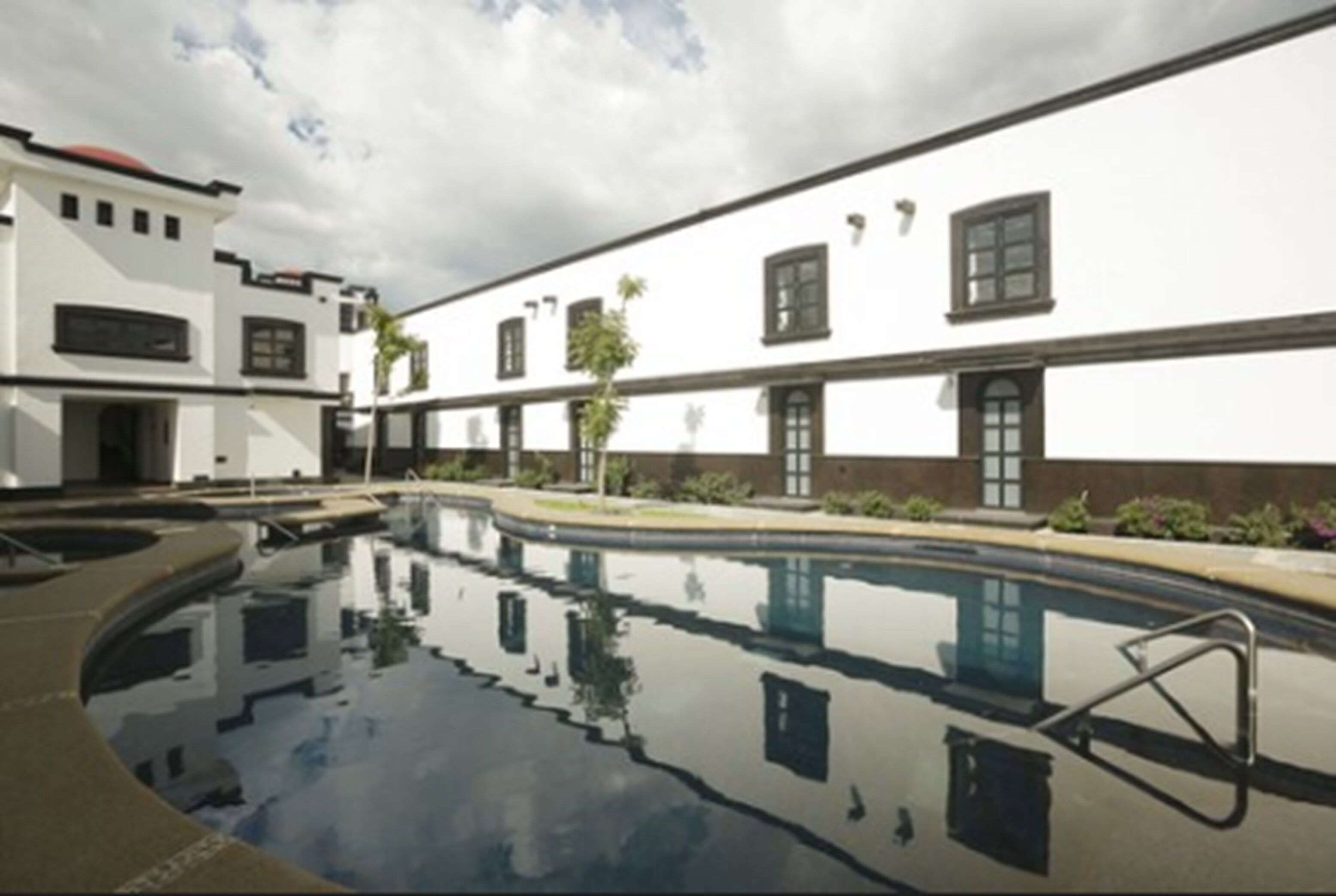 Un edificio moderno con una piscina que refleja su arquitectura.