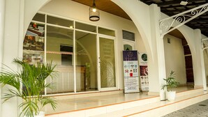 A modern building with a welcoming entrance, large glass doors, and a signboard advertising coffee and dining services. - Airlangga Hotel (Yogyakarta)