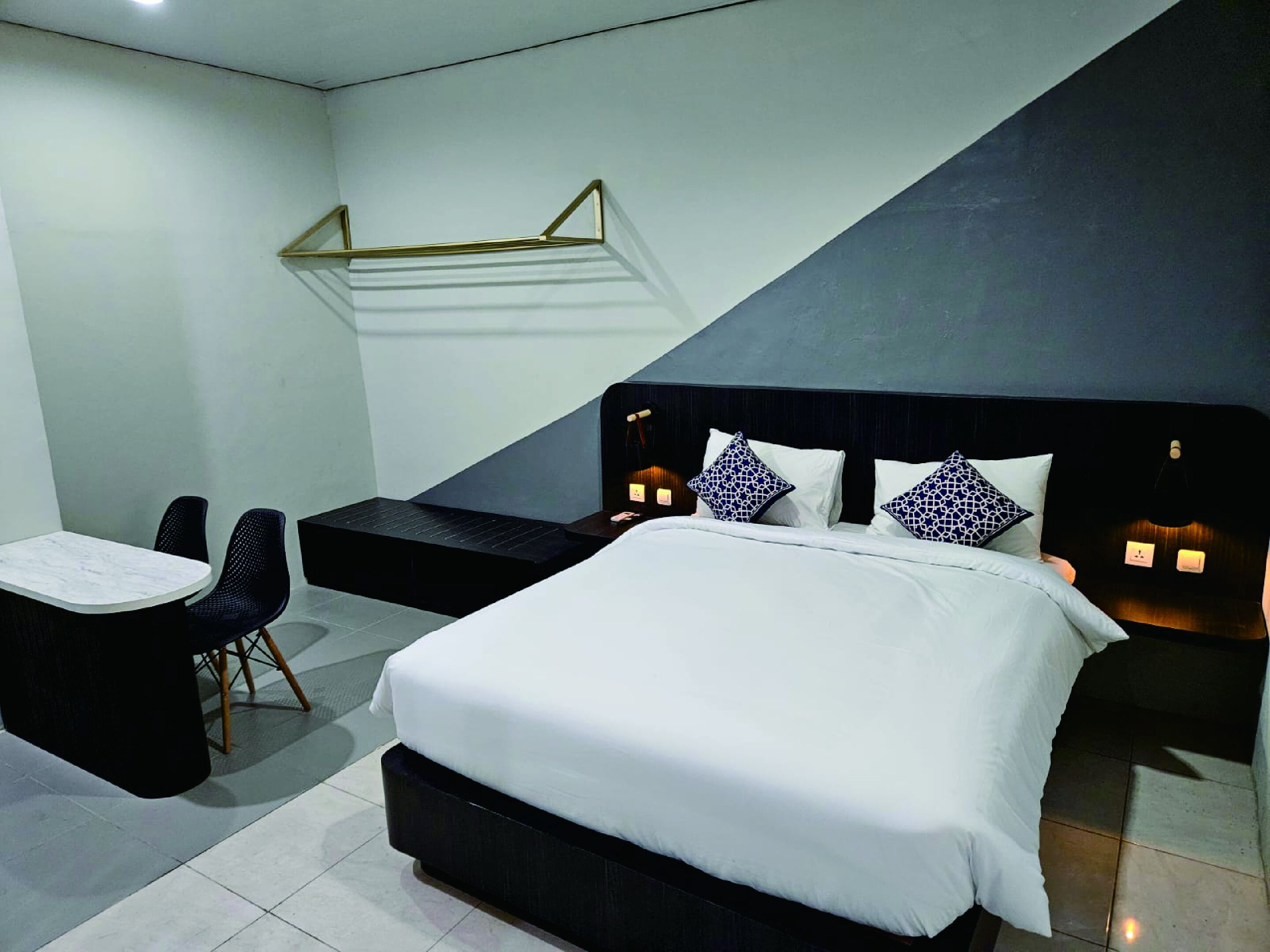 Una habitación de hotel moderna con una cama grande, un escritorio y una silla.