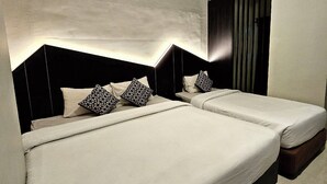 A modern hotel room with two beds, a large window with blinds, and a minimalist design. - Airlangga Hotel (Yogyakarta)