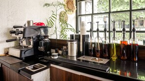 A coffee bar with an espresso machine, coffee cups, and various coffee dispensers. - Airlangga Hotel (Yogyakarta)