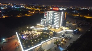 Un hotel con patio central, varios pisos y zona de estacionamiento.