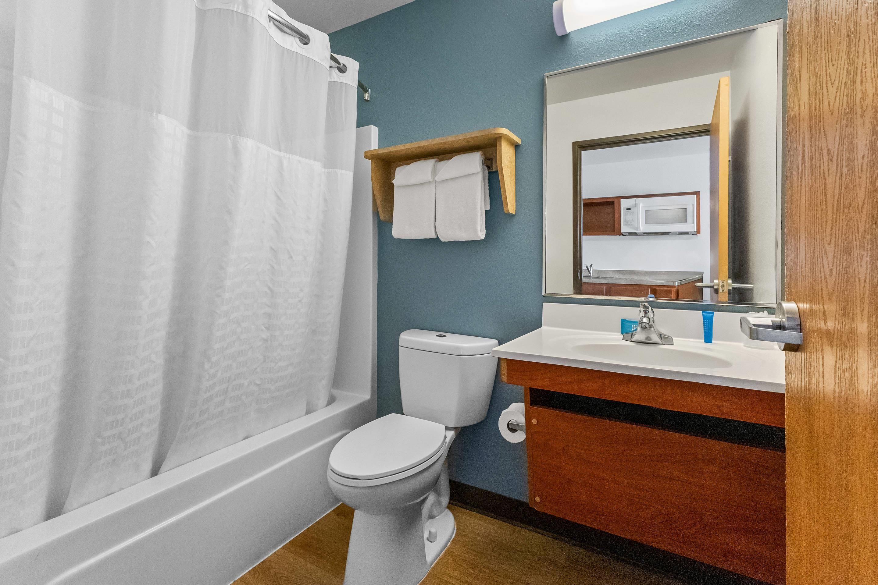 A bathroom with a bathtub, toilet, sink, and a mirror.