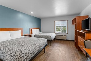 A hotel room with two beds, a TV, and a window with blinds. - WoodSpring Suites Chesapeake - Norfolk Greenbrier (Chesapeake)