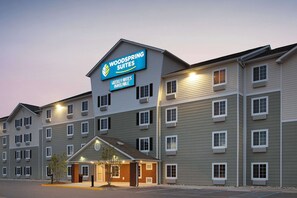 A multi-story hotel with a sign indicating "Woodspring Suites" and "Weekly Rates Available". - WoodSpring Suites Chesapeake - Norfolk Greenbrier (Chesapeake)