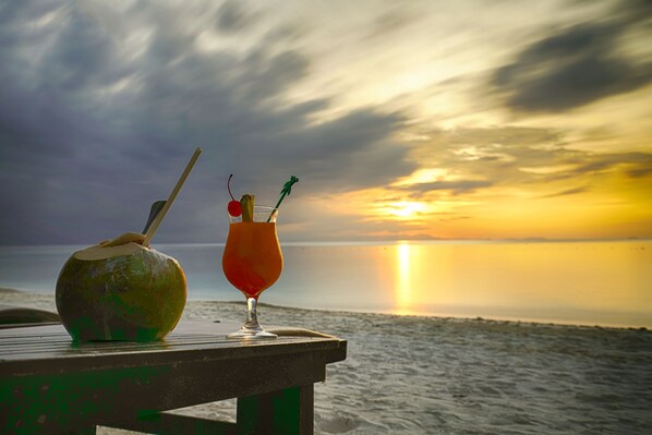 A sunset view with a beach and two drinks on a bench. - Summer Bay Resort, Lang Tengah Island (Lang Tengah Island)