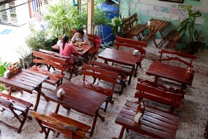 Enjoy casual dining in a relaxed, open-air setting surrounded by lush greenery and a water feature.