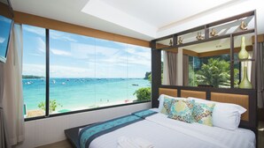 A hotel room with a large window offering a view of the sea and boats. - Phi Phi Nice Beach Hotel Hip (Ko Phi Phi)