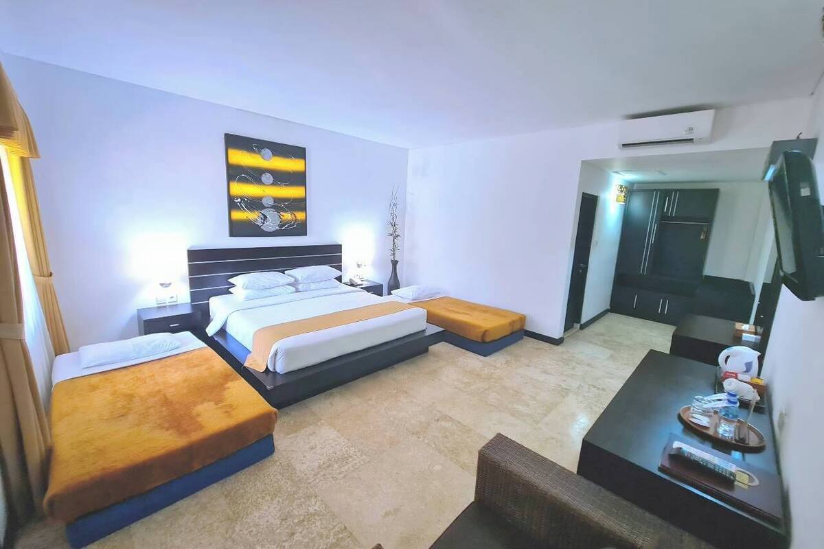 Una habitación de hotel con cama, mesitas de noche, escritorio y una silla.