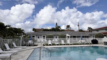 Een buitenzwembad, parasols voor strand/zwembad