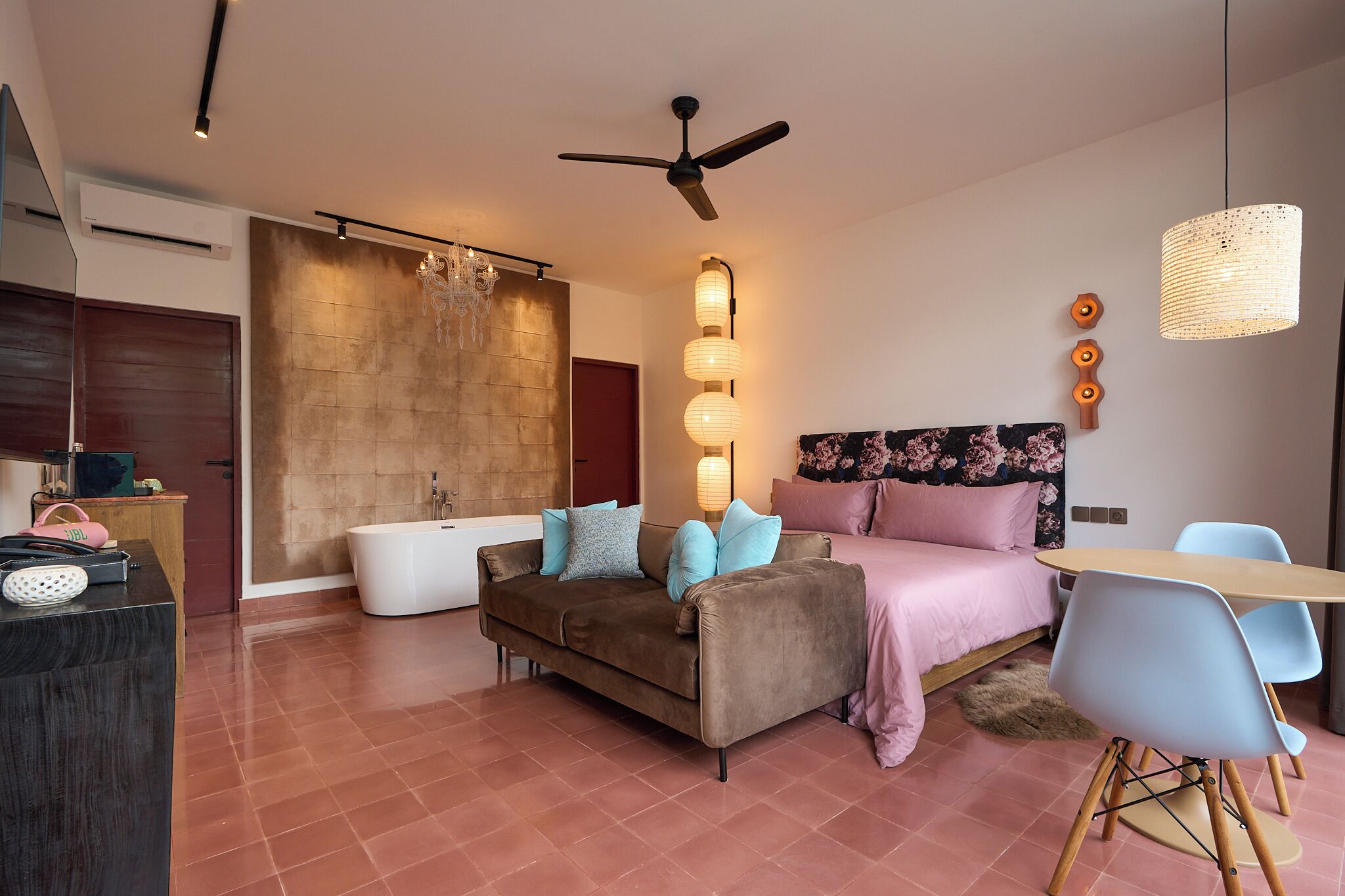 Un dormitorio moderno con sofá, cama, escritorio y baño.